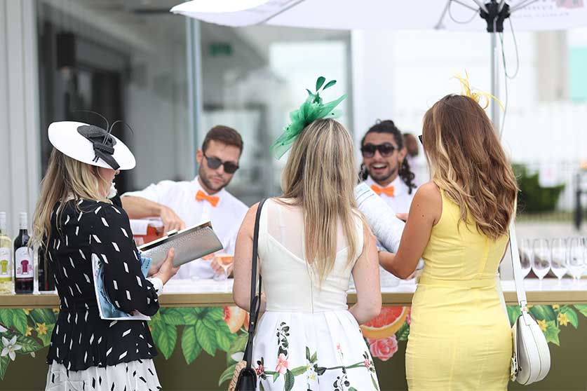 Guests in fancy dresses at the drinks corner at Queen's Plate 2022 at Woodbine Racetrack