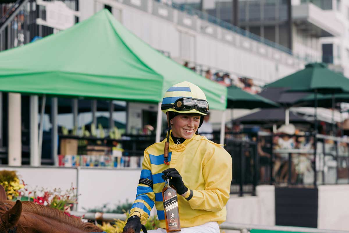 a female jockey at the King's Plate displaying Johnny Walker vhiskey