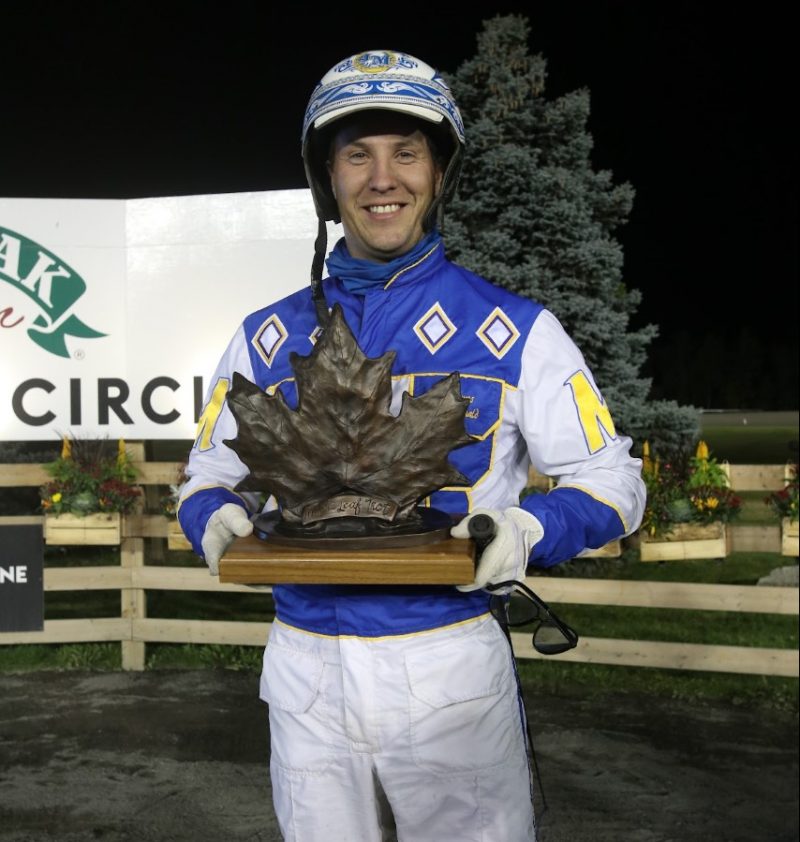 James MacDonald, the 2021 leading Canadian driver, poses in the winner's circle after winning the Maple Leaf Trot. He will have four attempts to reach the winner's circle in the Breeders Crown at the Meadowlands. (New Image Media)