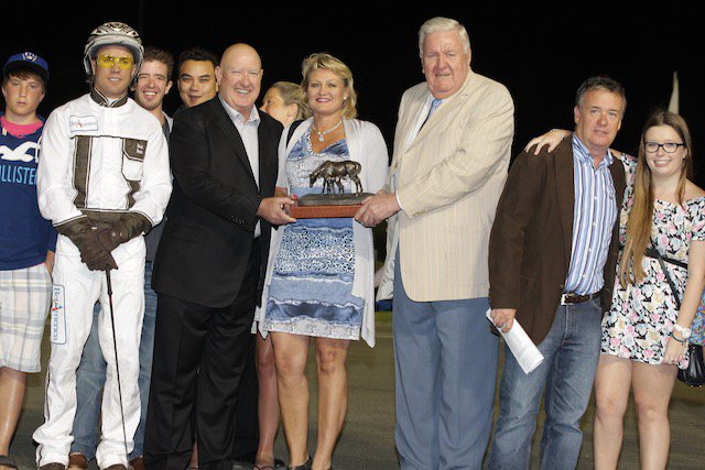 Dr. Glen Brown (third from right) presents the Fan Hanover Stakes trophy to the connections of 2011 winner See You At Peelers.