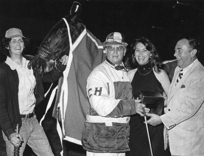 Famed Canadian-born horseman Clint Hodgins was a highly successful participant during the inaugural 1974 season. He’s shown here enjoying a jovial moment with OJC President John Mooney following a victory by his outstanding three-year-old pacing gelding Terry Parker. This horse led all competitors in earnings that first year as he banked a phenomenal $77,312 with $ 63,866 earned in OSS events alone. The groom at the left is Dennis Wicks.