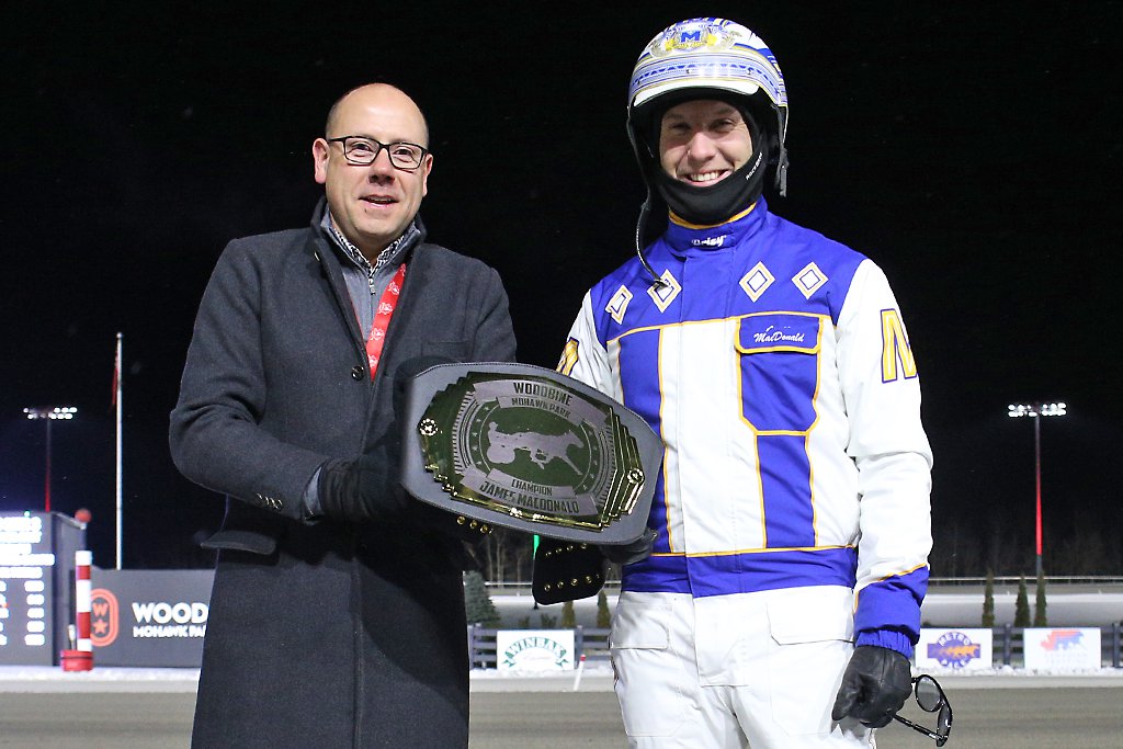 James MacDonald was awarded a special championship belt on Saturday, December 21, 2024 to recognize his fourth straight Woodbine driving title. Bill McLinchey, Vice-President of Standardbred Racing, made the presentation. (New Image Media)