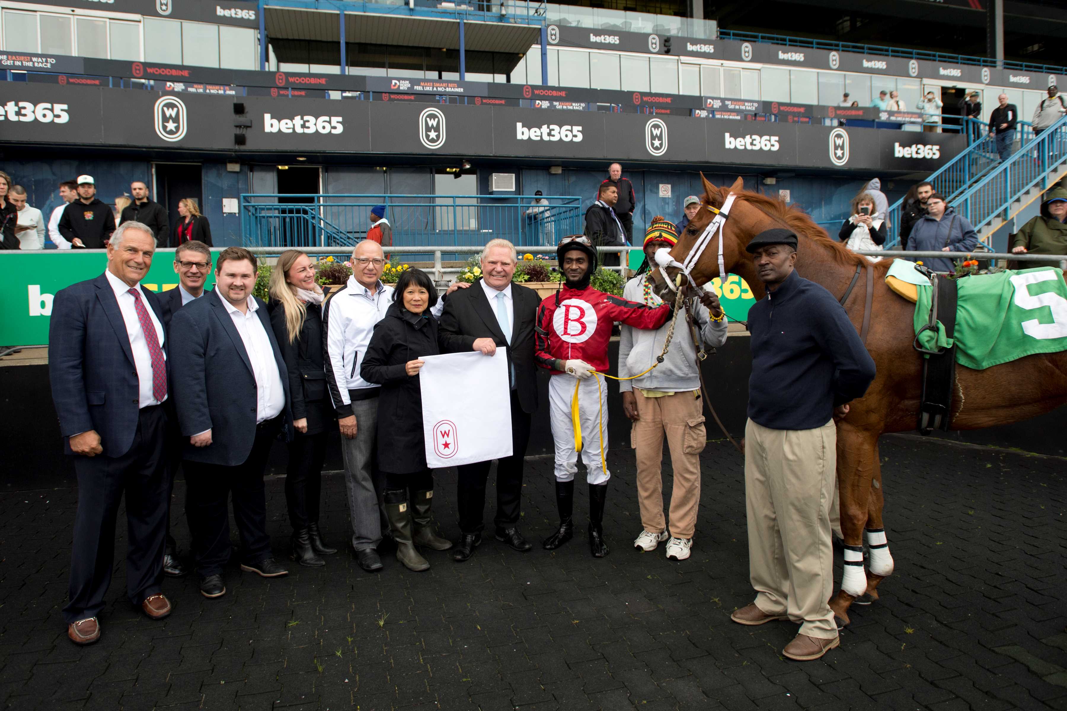(From left to right) Jim Lawson (Executive Chair, Woodbine, Michael Copeland (CEO, Woodbine), Minister Michael Ford, Councilor Vincent Crisanti, Mayor Olivia Chow, Premier Doug Ford, Jockey Jason Hoyte, trainer Ted Holder (Michael Burns Photo)