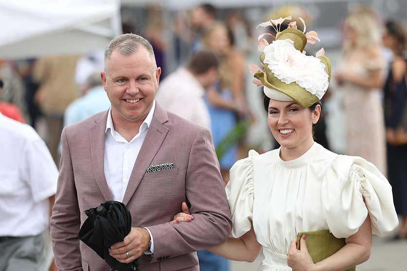 Fashion couple posing for a photo at the Queen's Plate at Woodbine Racetrack