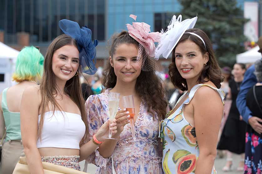 Guests in fancy dresses enjoying drinks at Queen's Plate 2022 at Woodbine Racetrack