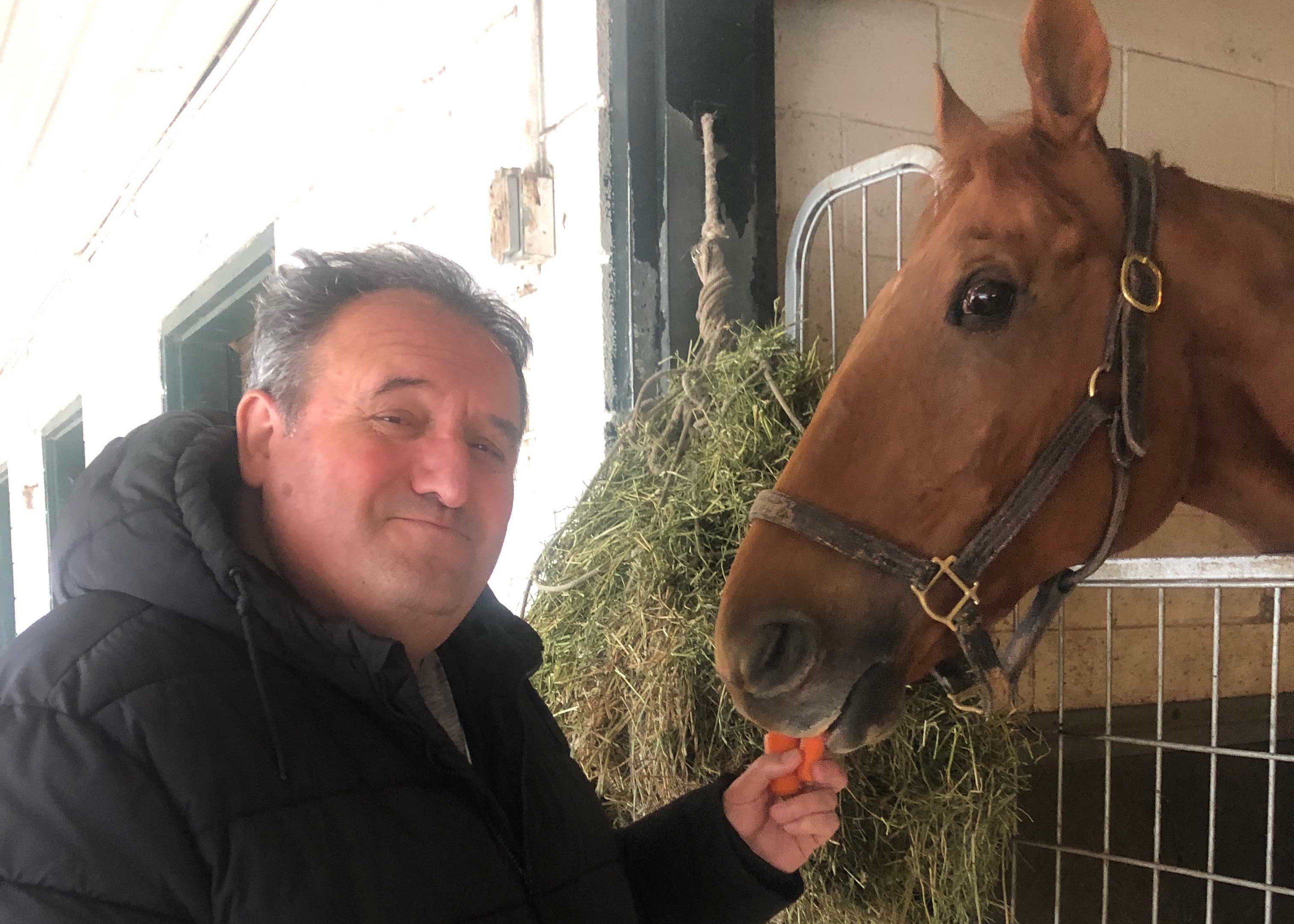 Co-owner of Eight Star Racing Stables Joe Mazarese feeding Lapochka carrots