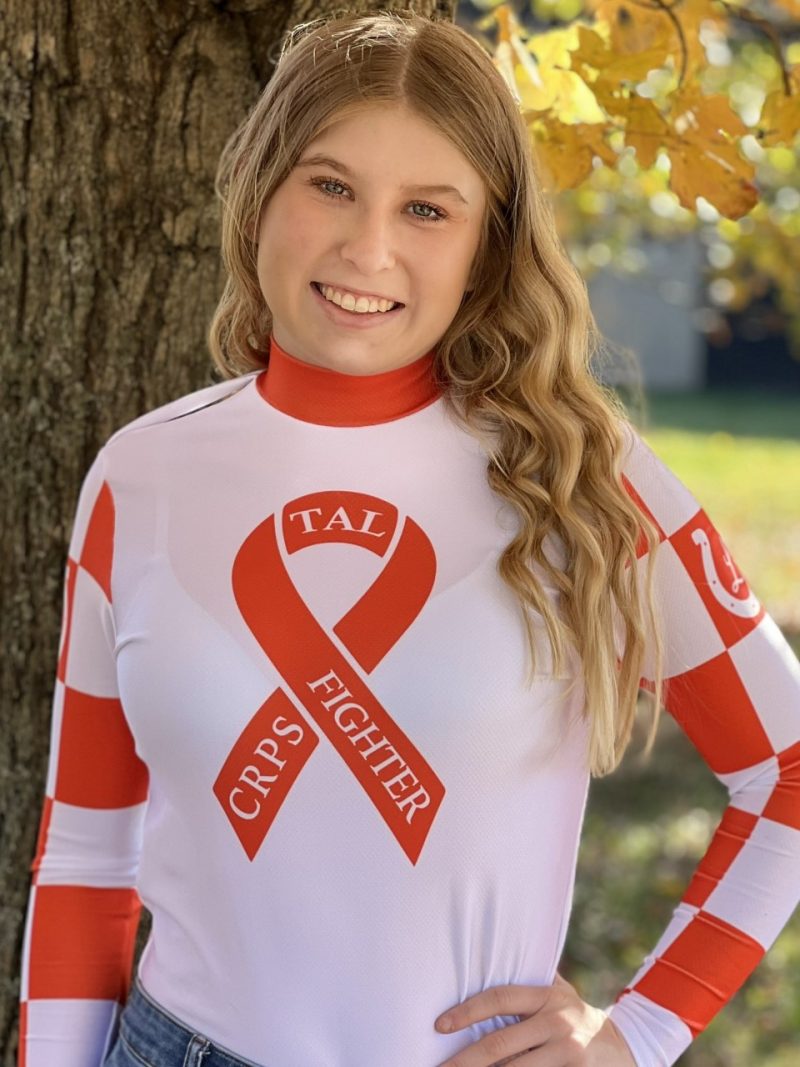 Taylor Logan wearing TEC Racing's orange silks to spread awareness for complex regional pain syndrome (CRPS) in her senior photo.